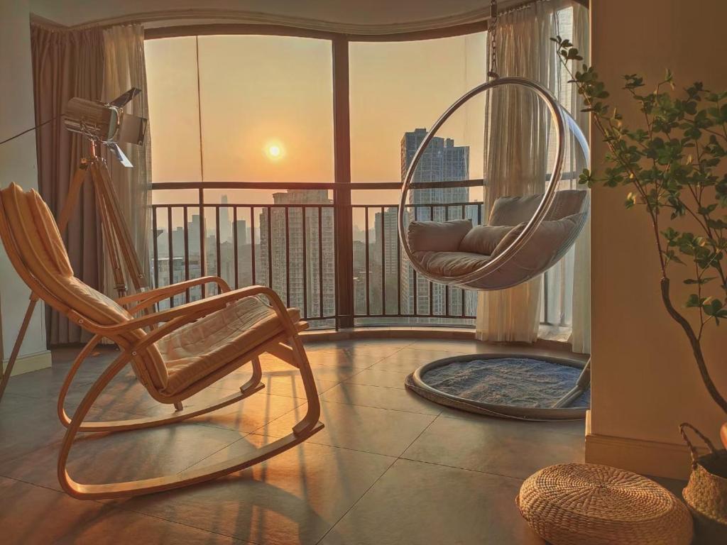 a room with two chairs and a balcony with a view at Chihiro Haven in Chongqing