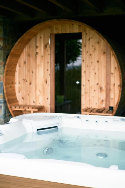 a bath tub in front of a wooden wall at Oklm6 in Mellet