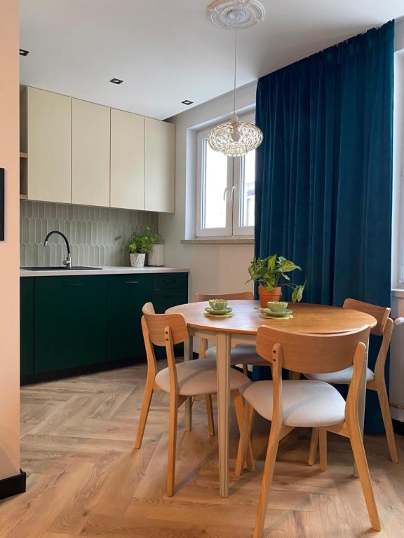 a kitchen with a table and chairs and a dining room at ZIELONE DRZWI Hajnówka in Hajnówka