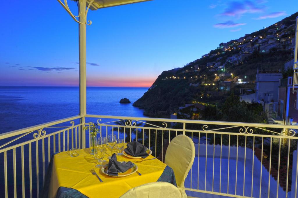 een tafel op een balkon met uitzicht op de oceaan bij Hotel Torre Saracena in Praiano