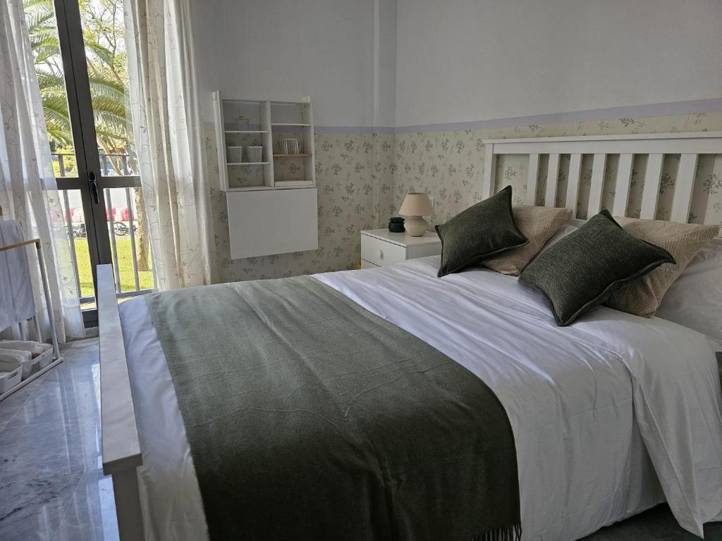 a bedroom with a large bed with green pillows at Solo or Couple , Solo o Pareja in Seville