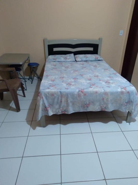 a bedroom with a bed and a table at kitinete - SALVATERRA GUARAMIRANGA in Guaramiranga