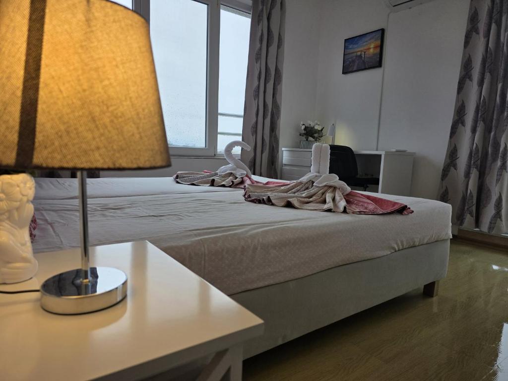 a hotel room with a bed with a table and a lamp at Perla View Apartment in Primorsko