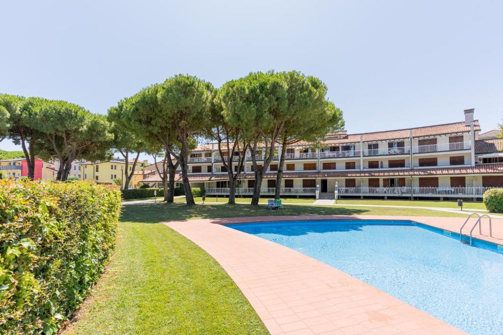 a swimming pool in front of a building at Residence Selenis Apartments in Caorle