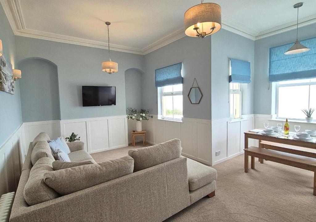 a living room with a couch and a piano at Seaview Cottage in Llanddulas
