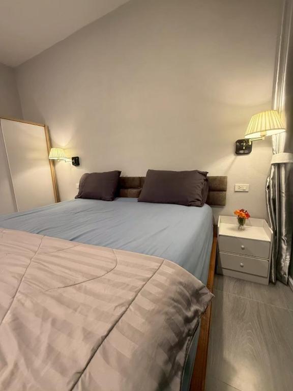 a bedroom with two beds and two lamps at Joyful House in Ban Dan