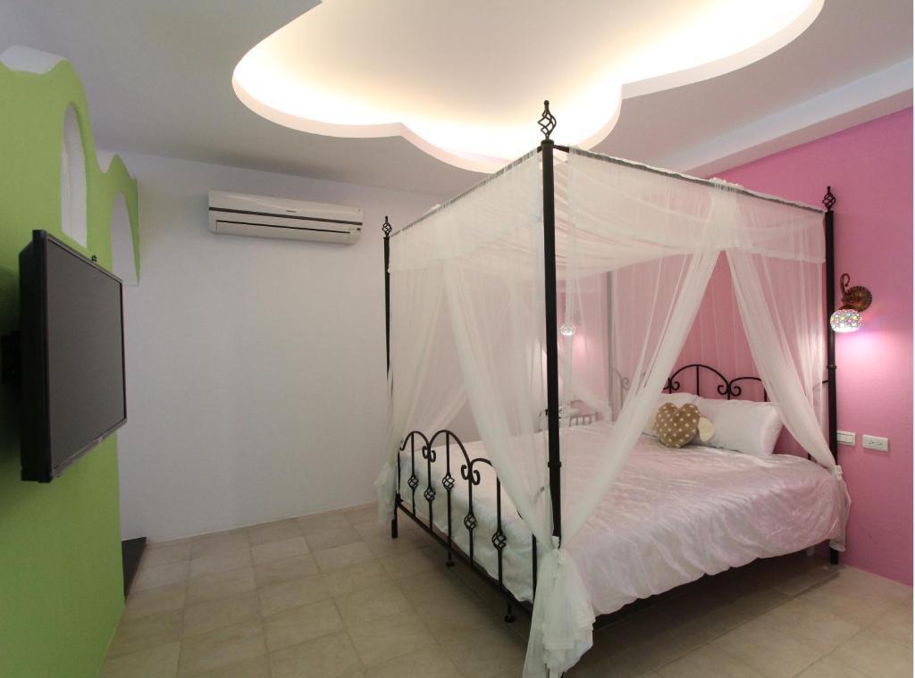 a bedroom with a bed with a canopy at Sky Blue Ocean B&B in Eluan
