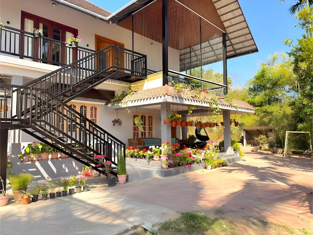a house with a staircase and flowers on it at Evara Stays Coorg in Kushālnagar