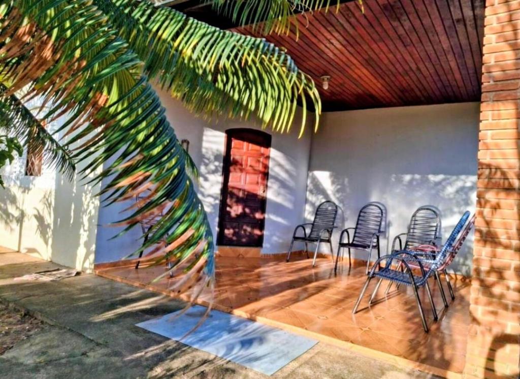 a room with chairs and a table and a palm tree at Espaço da Iza in São Pedro