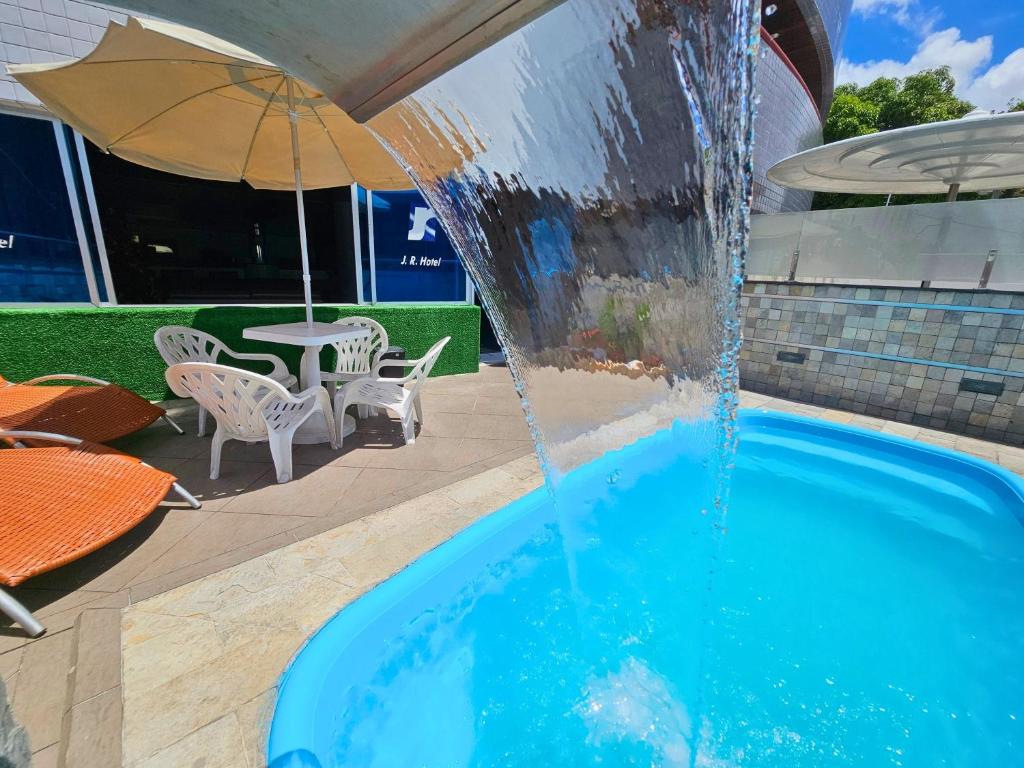 ein Schwimmbecken mit einem Springbrunnen in der Unterkunft JR Hotel in João Pessoa