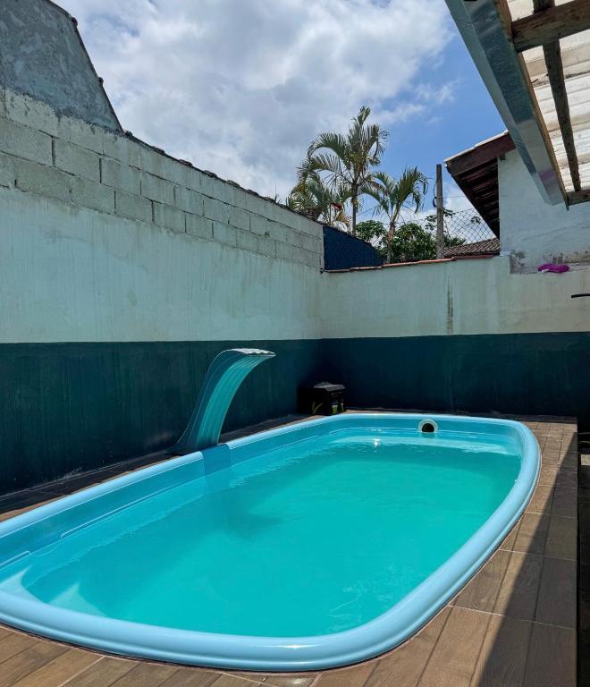 a hot tub with a plastic chair in a room at Ilhabela quarto próx praia in Ilhabela