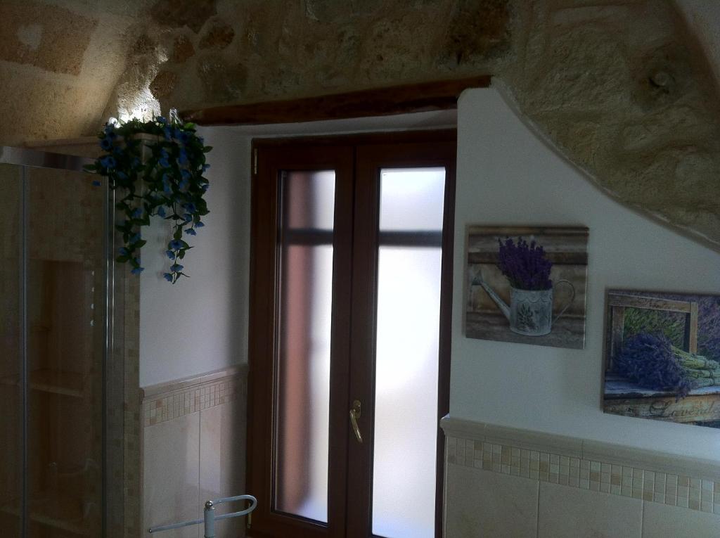a bathroom with a glass door and a window at Porta Piccola B&B in Mesagne