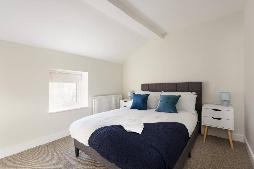 a bedroom with a large bed with blue pillows at Perfect 3 Bedroom Accommodation for Contractors! in Banbury