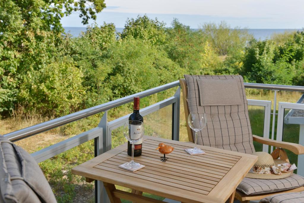 eine Flasche Wein auf dem Tisch auf dem Balkon in der Unterkunft Strandhuhn in Juliusruh