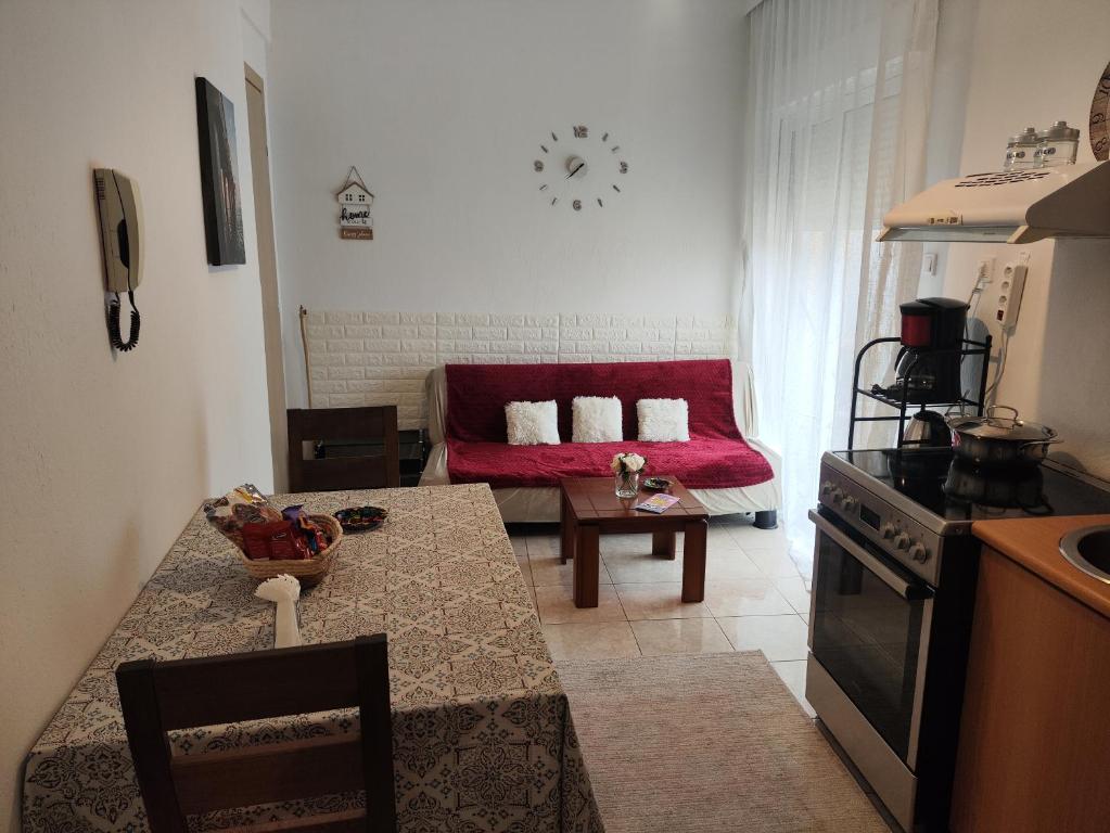 a kitchen and living room with a table and a couch at A & P Apartment in Xanthi