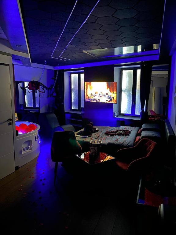 a living room with blue lighting and a couch at Redroom Spa privatif & nuit romantique à deux in Voiron