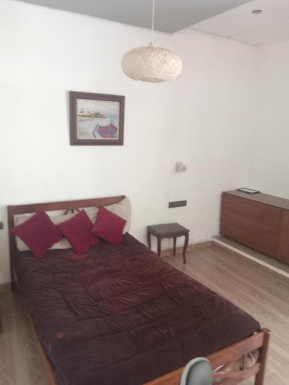 a bedroom with a bed with red pillows at Suite in nice résidence in Rabat