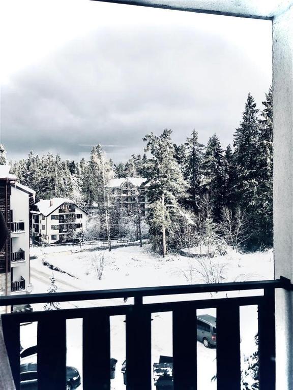 a view of a snow covered yard from a balcony at Borovets luxury studio in Samokov