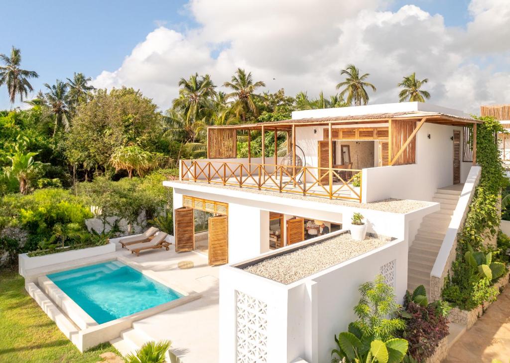 a villa with a swimming pool and a house at Coconut Villas Zanzibar in Matemwe