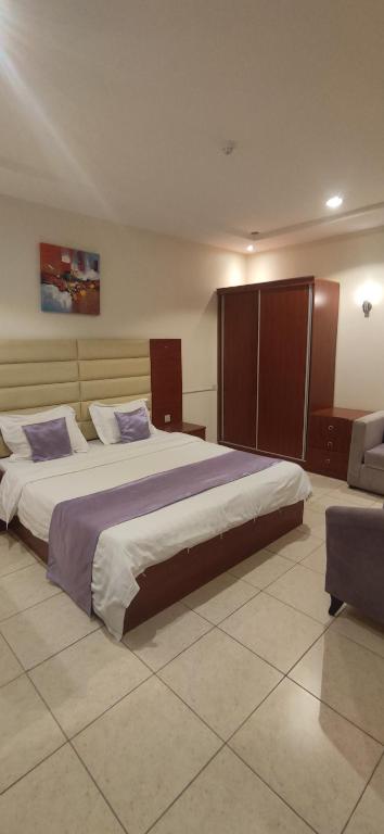 a large bedroom with a large bed and a couch at عمارة النفيسة السكنية in Unayzah