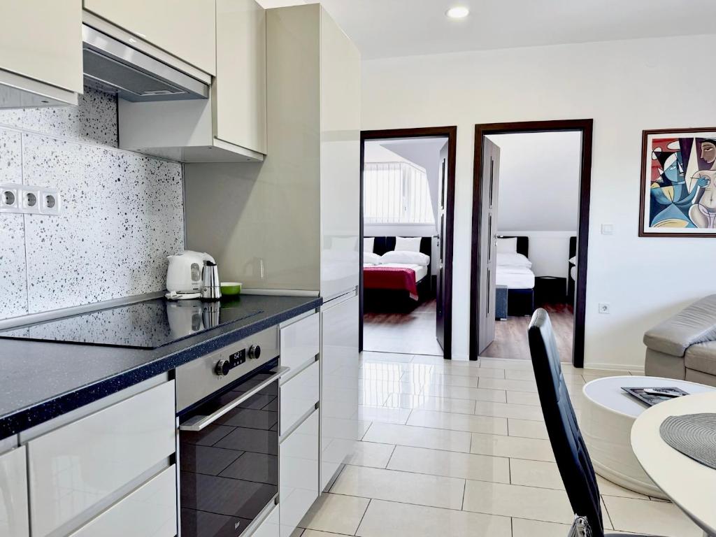 a kitchen with a counter top and a dining room at White Apartman Siófok in Siófok
