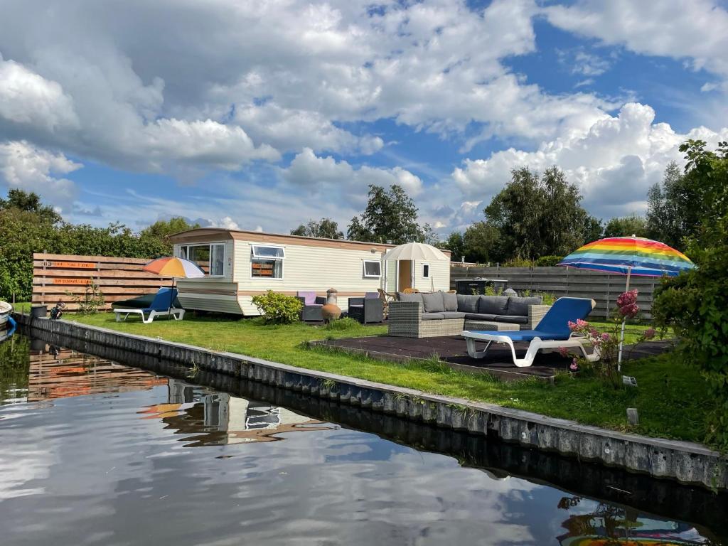 a caravan sitting next to a body of water at Houseboatvinkeveen Lelie in Vinkeveen