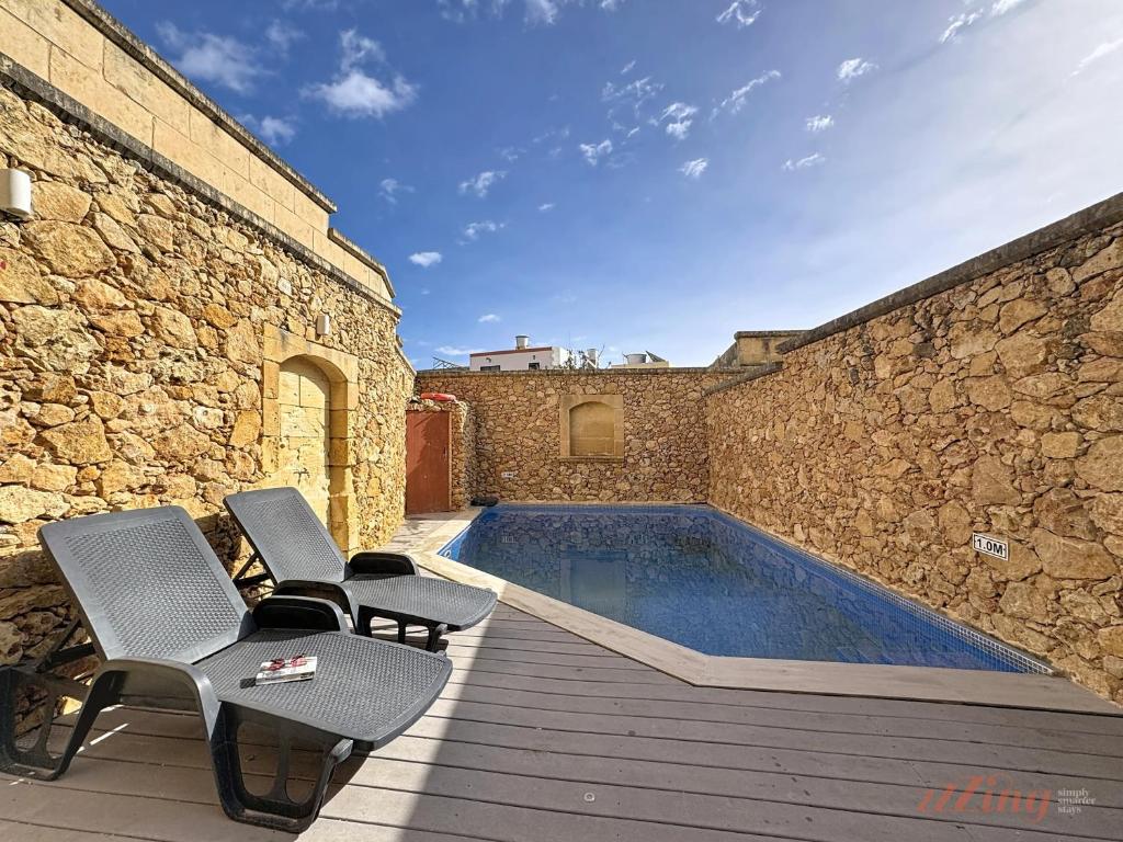 a patio with chairs and a swimming pool at Mia - Your Gozo Haven with Pool in Xagħra