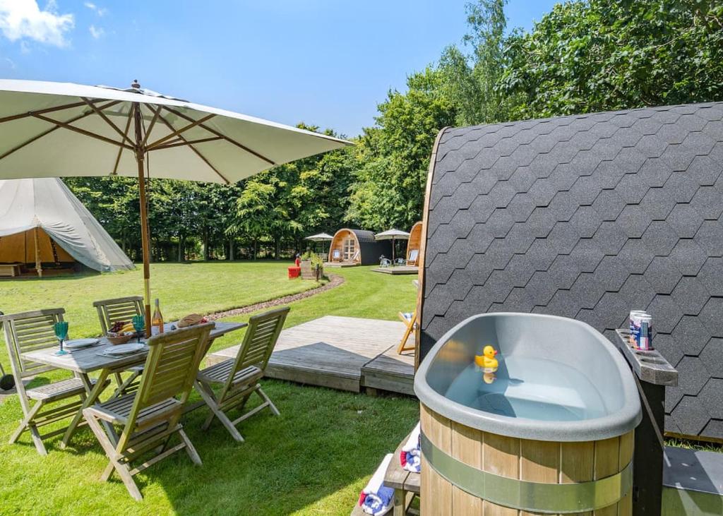 a hot tub in a yard with a table and chairs at Apple Mount Retreat in Preston