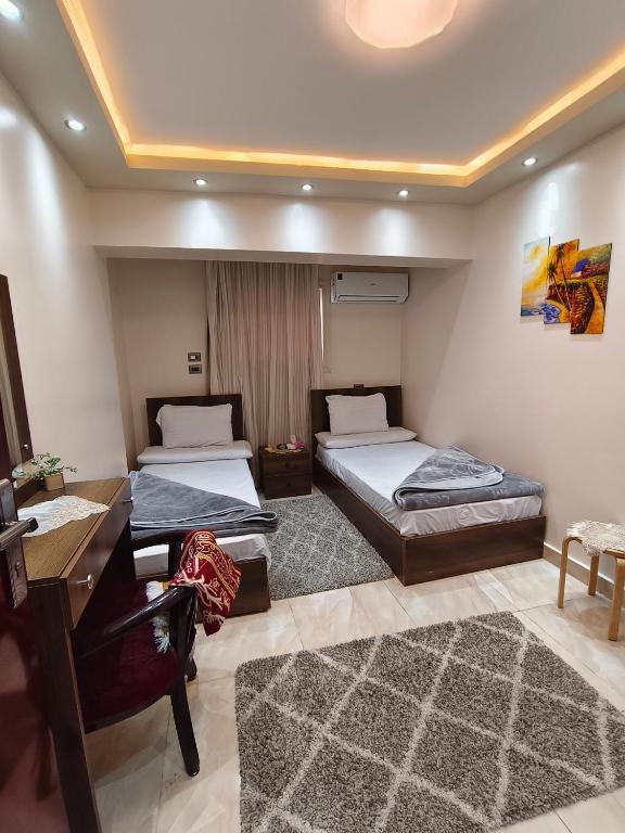 a bedroom with two beds and a desk and a desk at فندق أجياد Agyad Hotel in Asyut