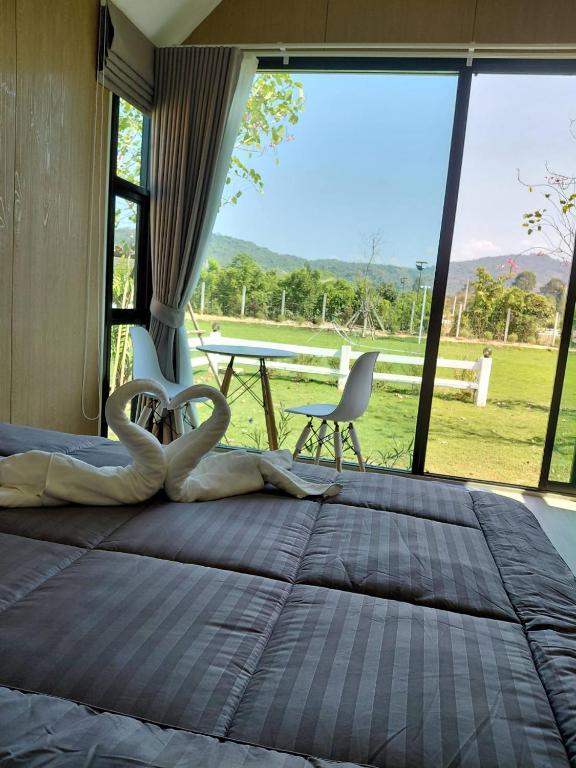 a bedroom with a large bed with a table and chairs at ลึกลับรีสอร์ทบ้านนา in Nakhon Nayok
