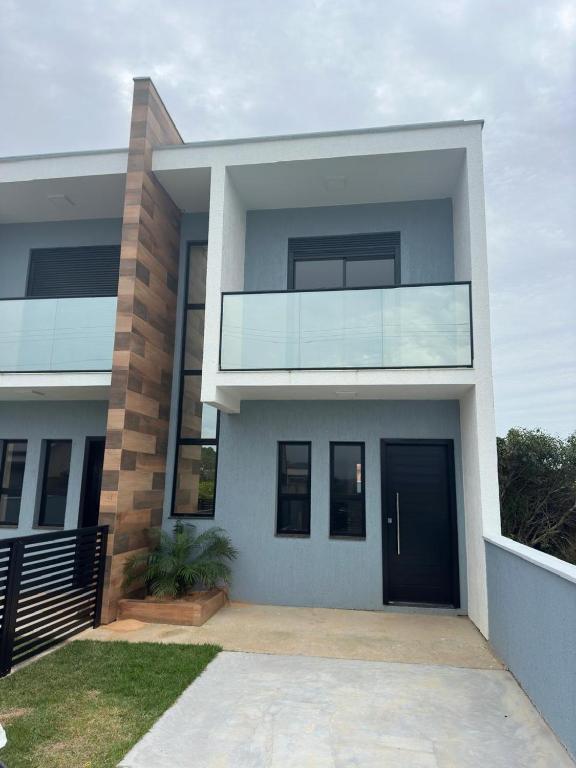a modern house with a black door at Casa geminada a 250 metros do mar in Imbituba