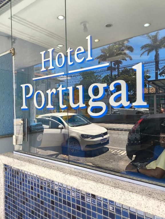 a reflection of a hotel portugal sign in a window at Hotel Portugal in Macaé
