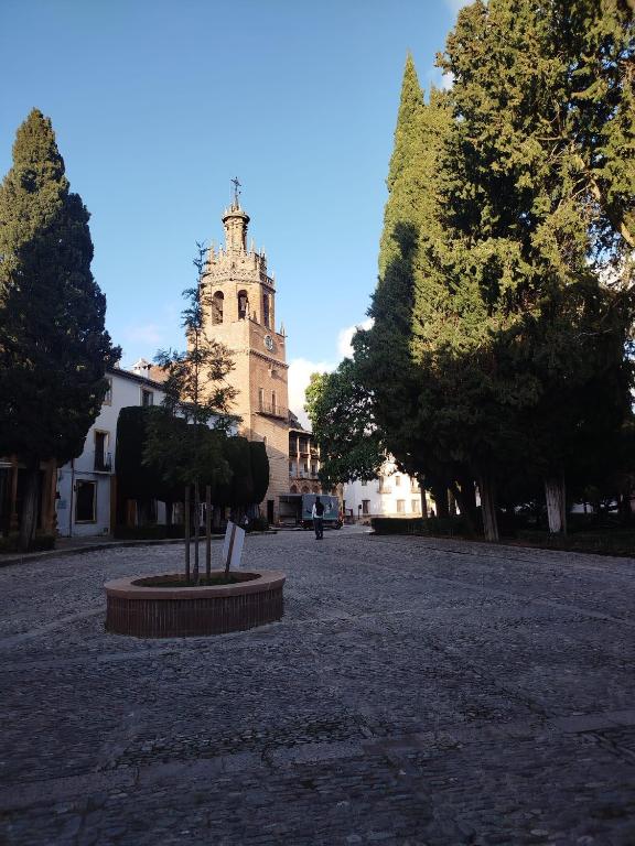 a building with a clock tower in the middle of a street at Suite Duquesa de Parcent in Ronda