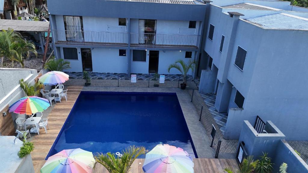 a swimming pool with umbrellas next to a building at Dk residêncial CASA INTEIRA in Pontal do Paraná