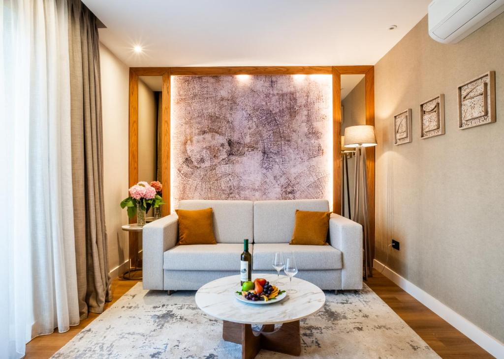 a living room with a white couch and a table at Boutique Hotel Villa Royal in Tivat