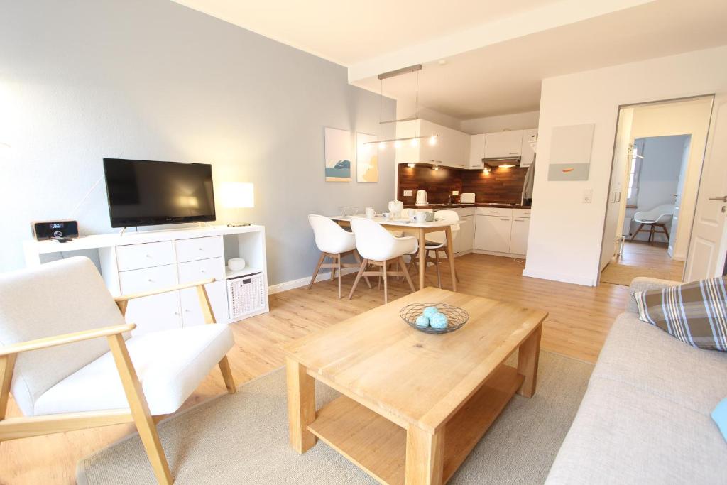 a living room with a couch and a table with a tv at MeerGlück in Langeoog