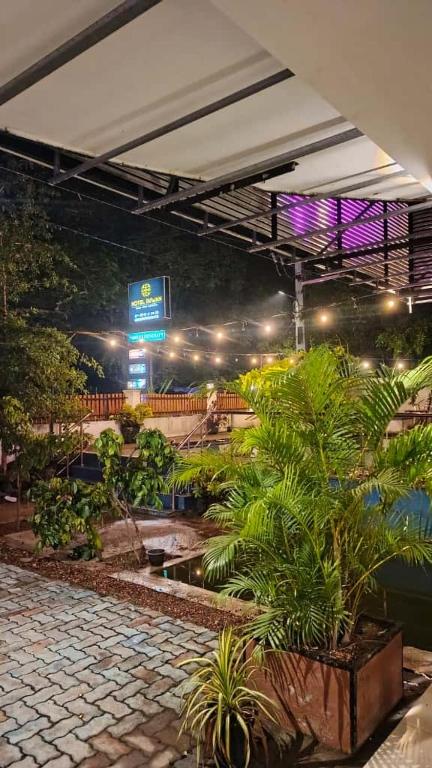 a building with a courtyard with plants and lights at Hotel Ruwan in Kataragama
