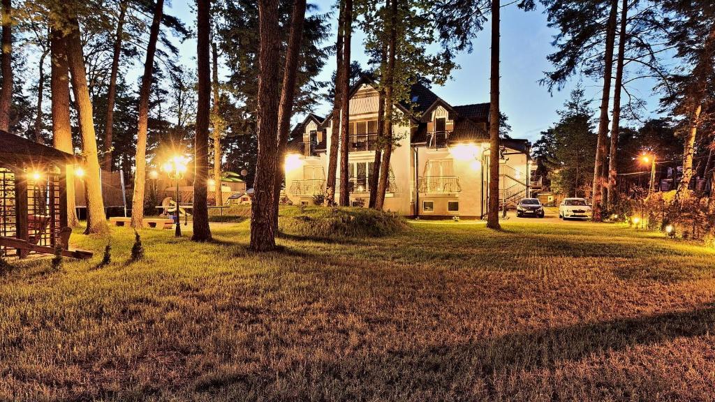 a house with lights in the yard at night at LC pokoje & apartamenty in Pobierowo