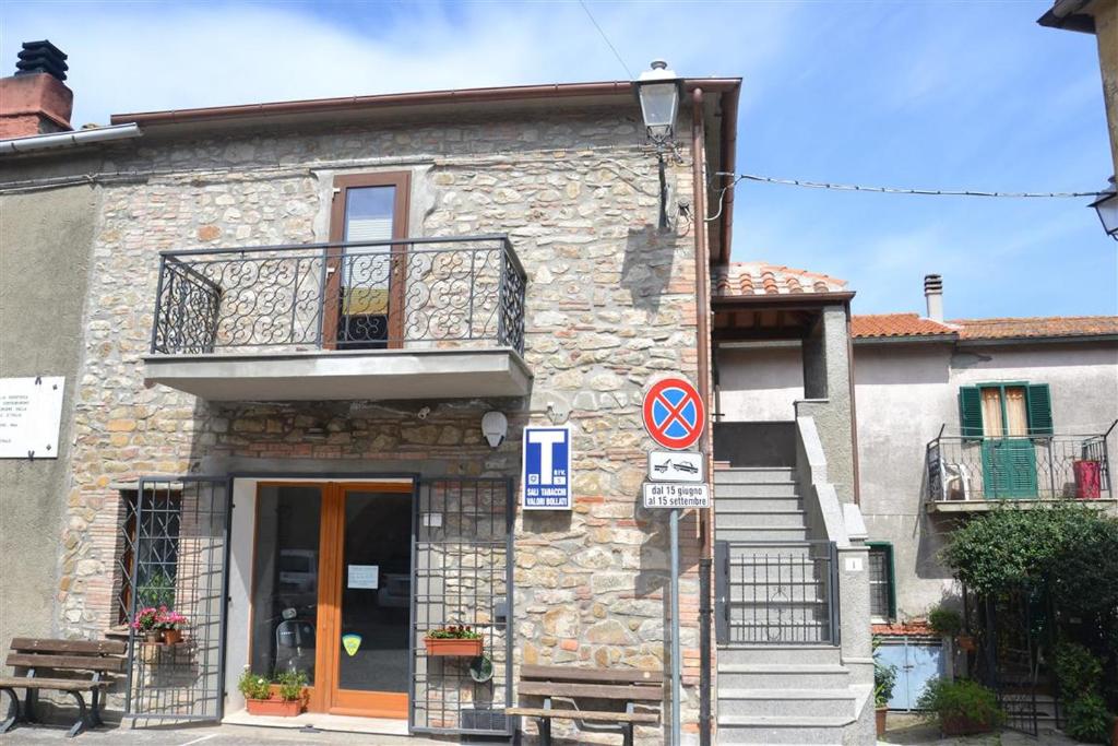 a stone building with a balcony and a door at Casa Tirli in Tirli