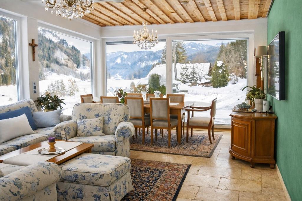 a living room with a table and chairs and a large window at Land - Haus in Pusterwald