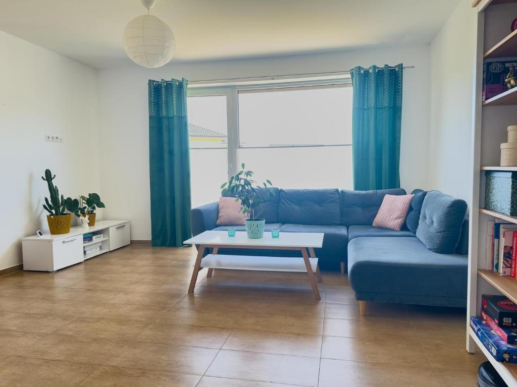 a living room with a blue couch and a table at Ferienwohnung in Neudenau