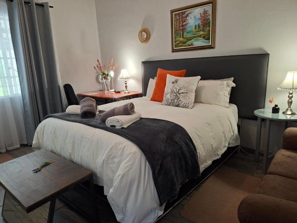 a bedroom with a large bed and a table at Altenburgh Accommodation - Apartments in Somerset East
