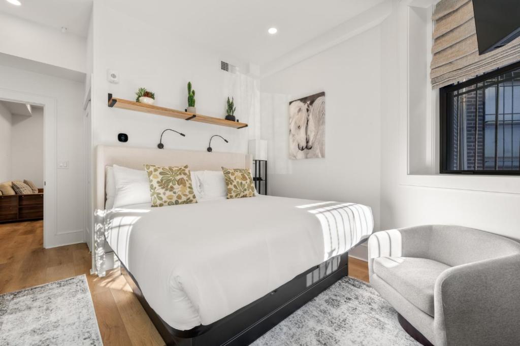 a white bedroom with a bed and a couch at SympleLive Hotel in Boston
