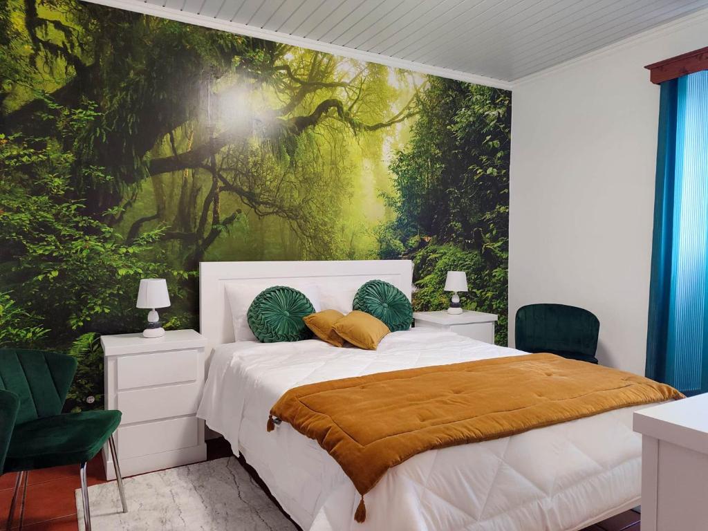 a bedroom with a bed with a tree mural at Paraíso Verde in Algarvia