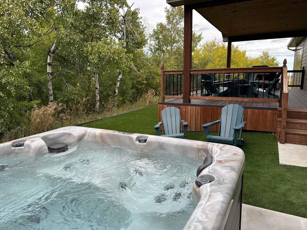 a hot tub in a yard with two chairs at Willow Creek Hideaway in Red Lodge