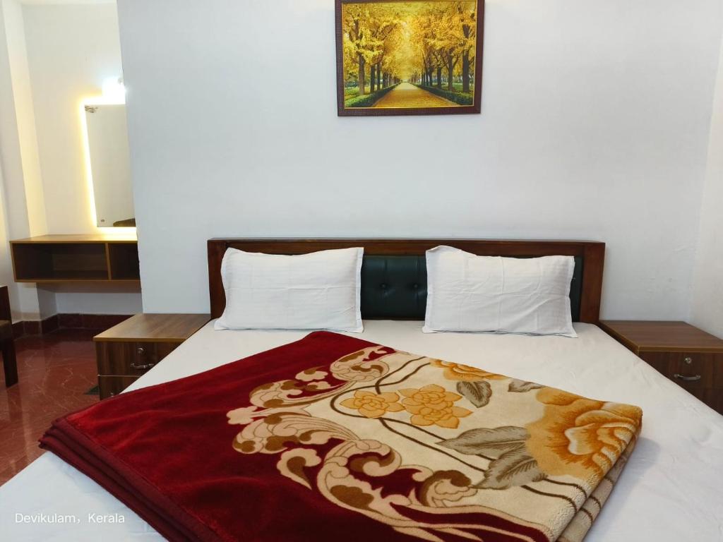 a bed with a red blanket on top of it at Rose Cottage in Devikolam