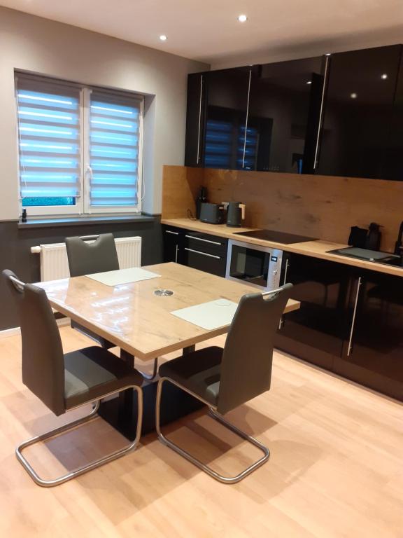 a kitchen with a wooden table and chairs at 100pro-Apartments in Detmold