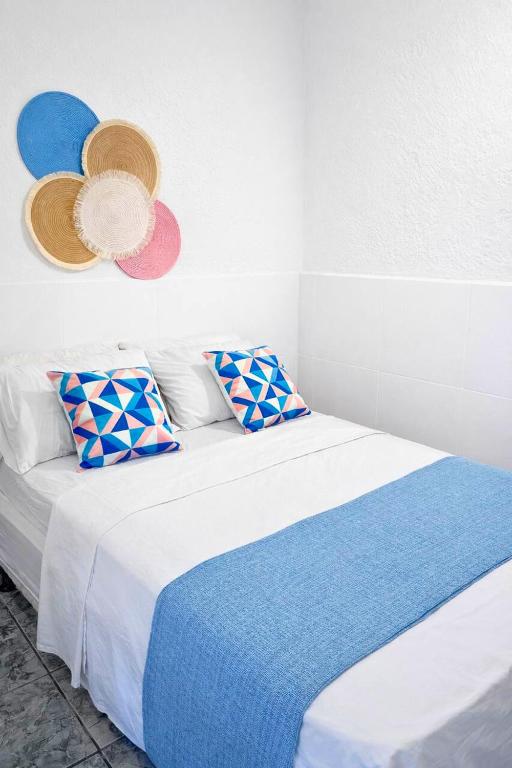 a bedroom with a bed with hats on the wall at Nalu Suítes Maresias in Maresias