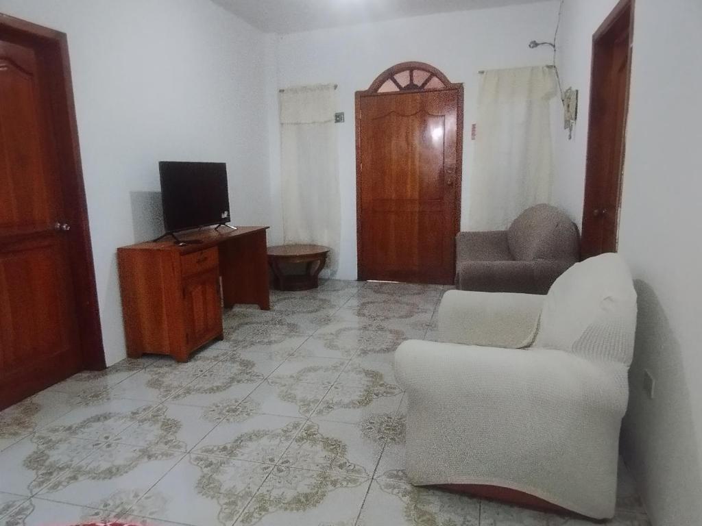 a living room with a couch and a tv at Casa JIREH in Puerto Ayora