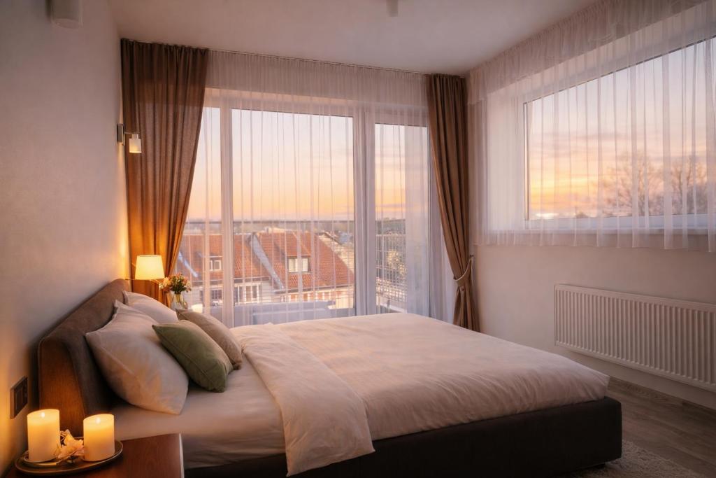 a bedroom with a large bed and a large window at Birštono Terasos in Birštonas